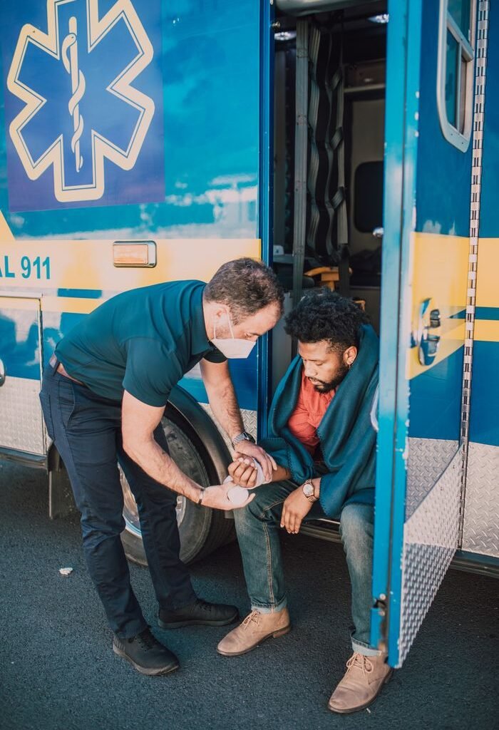 Paramedic tends to an injured person at ambulance entrance.