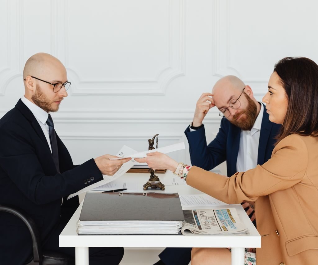 Professional meeting with lawyer and clients discussing documents in a modern office.