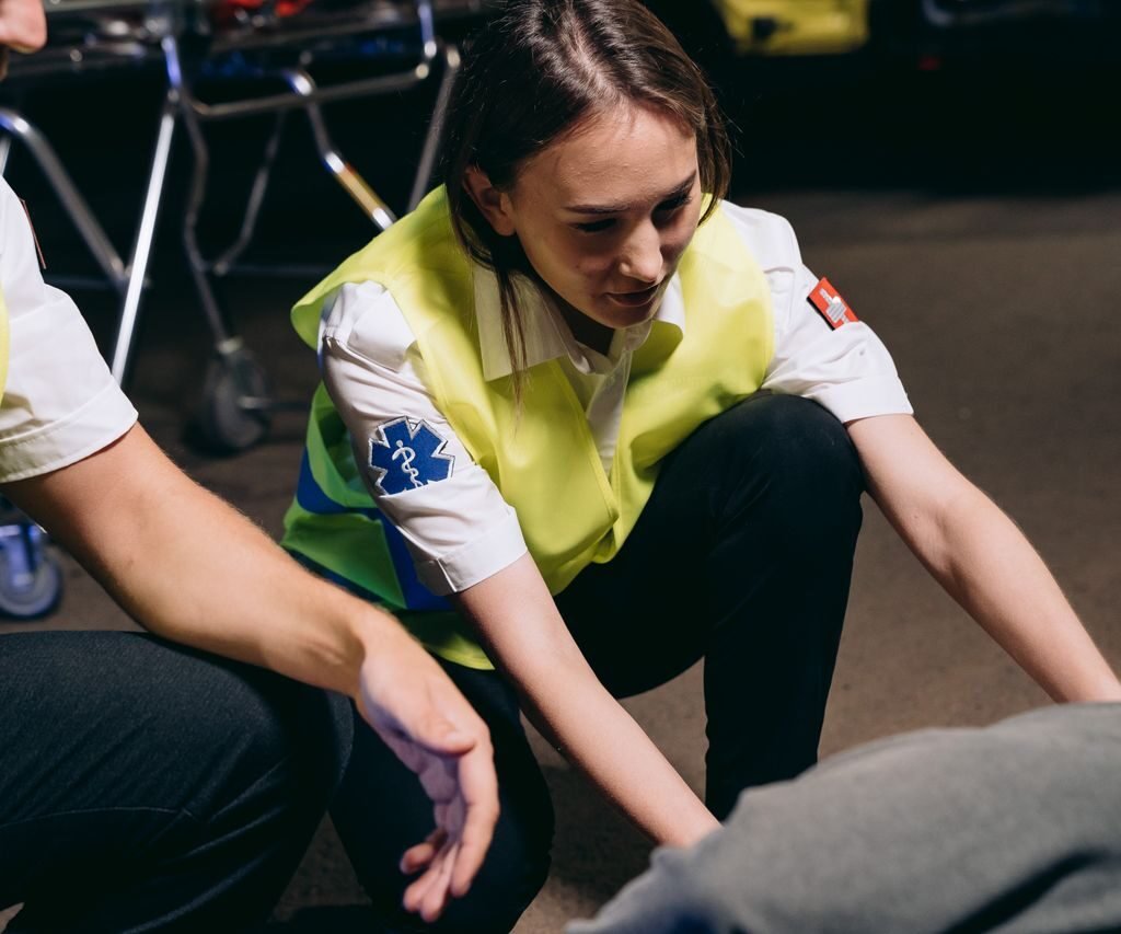 Two paramedics attend to a patient on the ground, providing emergency medical assistance.